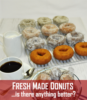 photo of a tray of a variety of donuts next to a cup of coffee, spoon, and pitcher of cream. Includes the words: Fresh made donuts ...is there anything better?